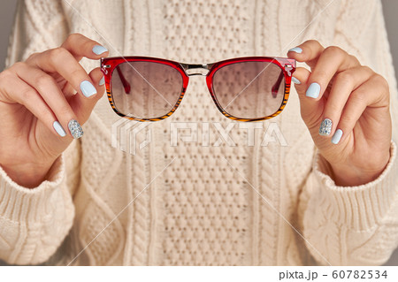 Manicure in blue colors. Woman fingers holding Manicure in blue colors. Woman fingers holding 60782534