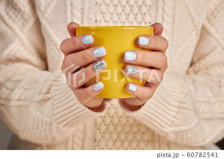 Women's hands holding a cup of tea. Women's hands holding a cup of tea. 60782541