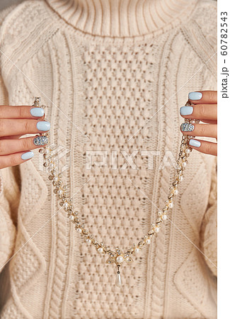 Beautiful necklace with pearls in a female hands. 60782543