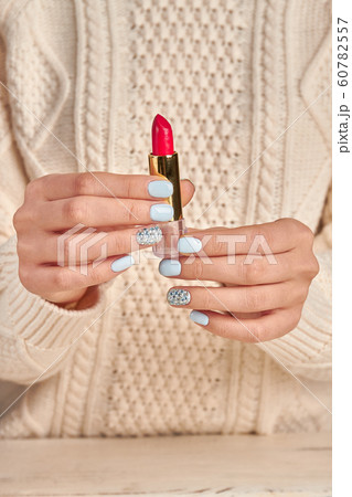 Red lipstick in female hands on a background of a Red lipstick in female hands on a background of a 60782557