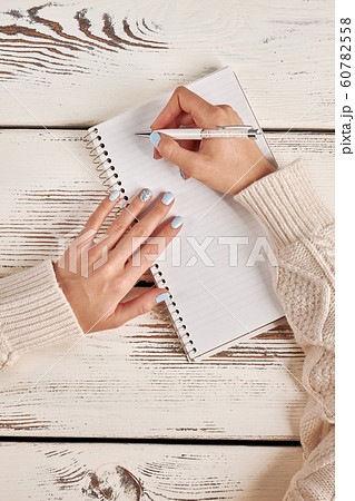 Writing in a notebook with a spiral. Signature on 60782558