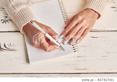 Beautiful female hands write in notebook. 60782561