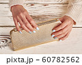 Beautiful golden clutch in women's hands. 60782562