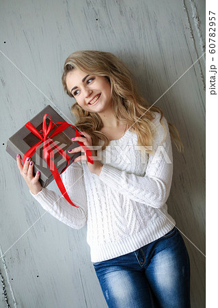 Woman holds a gift in a box on a birthday or new year Woman holds a gift in a box on a birthday or new year 60782957