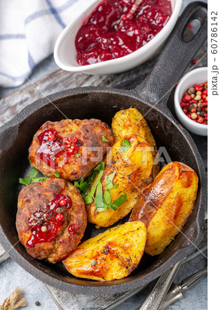 Meat cutlets and baked potatoes with lingonberry 60786142