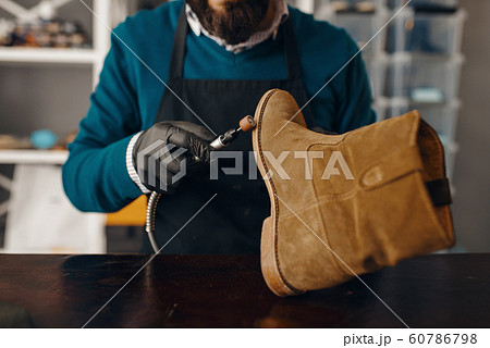 Shoemaker sharpens the shoe sole, footwear repair Shoemaker sharpens the shoe sole, footwear repair 60786798