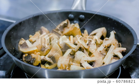 Champignon mushrooms frying and sizzling in pan Champignon mushrooms frying and sizzling in pan 60786821