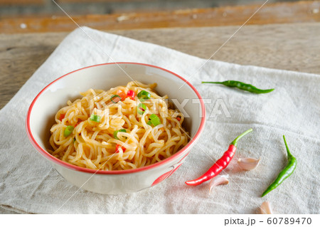 A cup of instant noodles placed on a wooden table 60789470