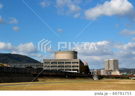六甲山系を背景に武庫川の河川敷公園から見た宝塚市役所 60791755