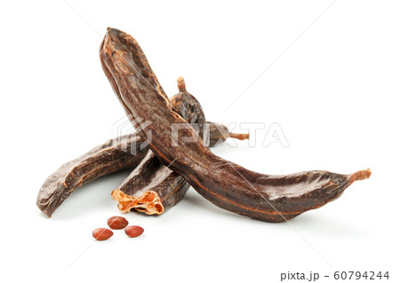Carob carob fruit and seeds on white background. Carob carob fruit and seeds on white background. 60794244