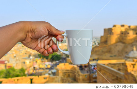 Hand holding a white cup 60798049