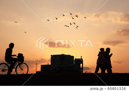 夕暮れの帰り道 学生 恋人たちと真っ赤な夕焼空 シルエット画像 広島県の写真素材