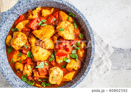 Jalfrezi chicken in fried pan with a bowl of rice Jalfrezi chicken in fried pan with a bowl of rice 60802592