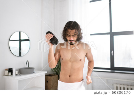 Energetic guy with portable wireless bluetooth speaker dancing in bathroom Energetic guy with portable wireless bluetooth speaker dancing in bathroom 60806170