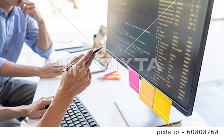 Pensive programmer working on on desktop pc 60808768