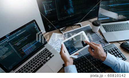 Programmer Typing Code on desktop computer, 60810142