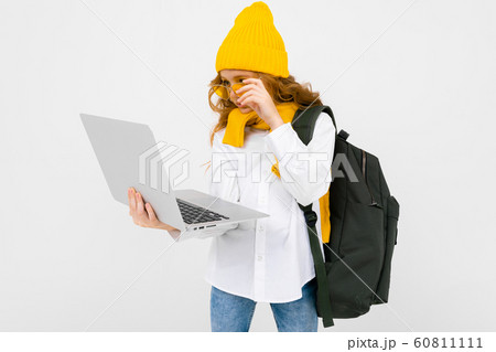 student girl in casual clothes with a backpack and with a laptop in her hands walking and reading student girl in casual clothes with a backpack and with a laptop in her hands walking and reading 60811111