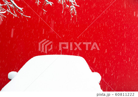 View of a snow-covered car on a background of a red wall during a snowfall. The concept of road safety, gift, christmas, insurance, winter. View of a snow-covered car on a background of a red wall during a snowfall. The concept of road safety, gift, christmas, insurance, winter. 60811222