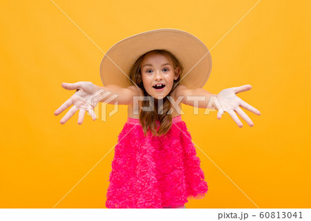 portrait of a happy cheerful charming beautiful young girl with a straw hat on her head holding out portrait of a happy cheerful charming beautiful young girl with a straw hat on her head holding out 60813041
