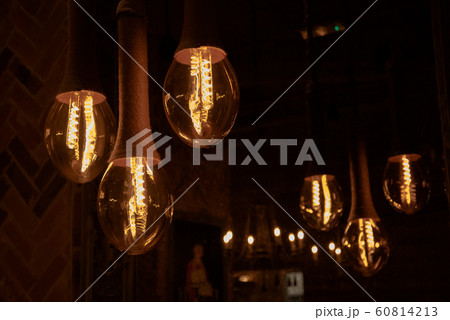 Decorative antique Edison style light bulbs on the background of a mirror that reflects the light bulbs. 60814213