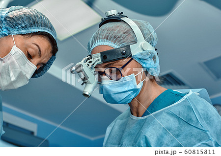 Two surgeons in protective uniform during the operation, on background of surgical room. Point of view shot 60815811