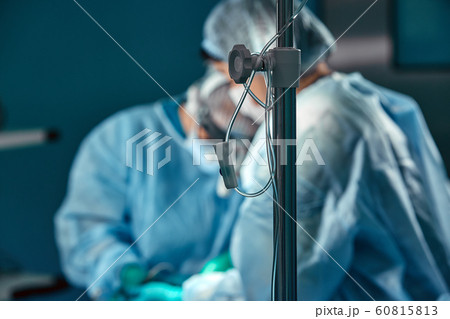 Two surgeons in protective uniform during the operation, on background of surgical room. Point of view shot 60815813