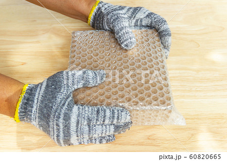 hand of man hold bubble wrap, for protection hand of man hold bubble wrap, for protection 60820665