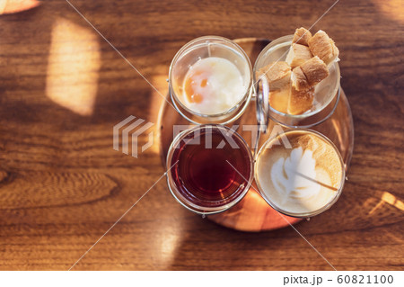 Vintage hot coffee set with soft boiled eggs and toasted sticks on wooden table in morning sunlight Vintage hot coffee set with soft boiled eggs and toasted sticks on wooden table in morning sunlight 60821100
