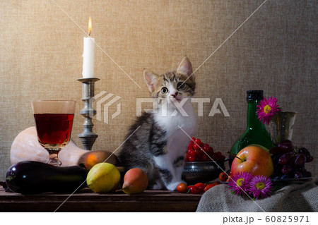 rustic still life with kitten pumpkin grapes dog rose green bottle grapes viburnum apples glass and tin glasses and a burning candle in a candlestick 60825971