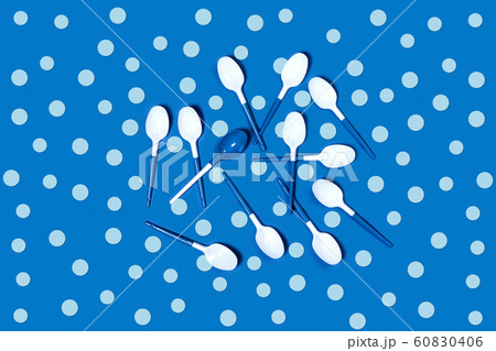 White plastic spoons on blue background. White plastic spoons on blue background. 60830406