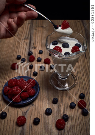 man eating yogurt with raspberries and blueberries 60831561