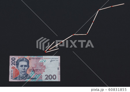 Sulfur arrow and 200 hryvnia on black background. 60831855
