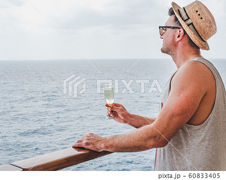 Man holding glass on the open deck 60833405