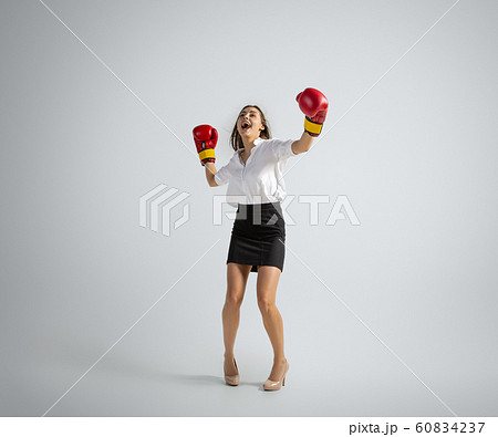 Caucasian woman in office clothes boxing isolated on grey studio background Caucasian woman in office clothes boxing isolated on grey studio background 60834237
