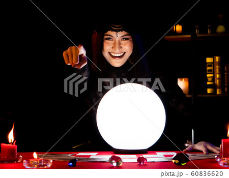 The witch is casting a spell to perform a ritual. 60836620