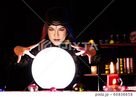 The witch is casting a spell to perform a ritual. 60836658