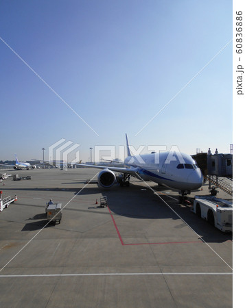 晴れた日の空港のエプロンで搭乗客を待つジェット機 縦位置 の写真素材 6066