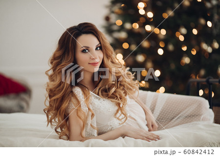 Happy pretty young pregnant lady lying on bed and 60842412