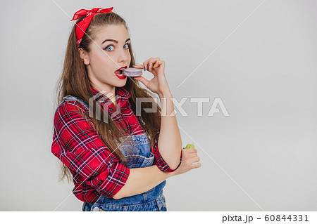 Beautiful cute young girl tasting enticingly delicious yummy macaroon. Showing her approval. 60844331