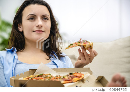 Caucasion woman eats delicious pizza, isolated, at home. Close up. Copy space. 60844765