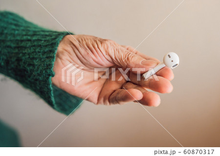 Senior woman listening to music on his smartphone, using modern wireless headphones 60870317
