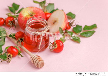 Fresh rose hip berries, apple and honey on pink 60871099
