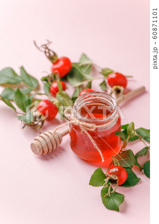 Fresh rose hip berries and honey on pink 60871101