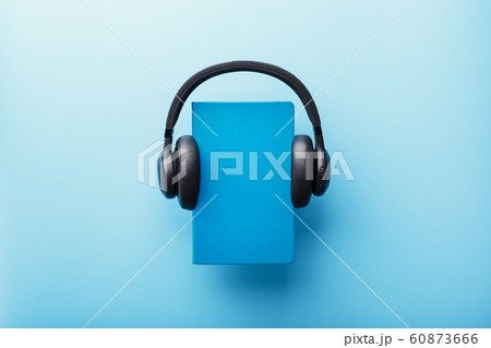 Headphones are worn on a book in a blue hardcover Headphones are worn on a book in a blue hardcover 60873666
