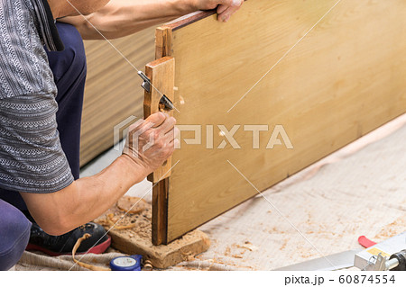 引き戸をカンナで削る建具職人の写真素材
