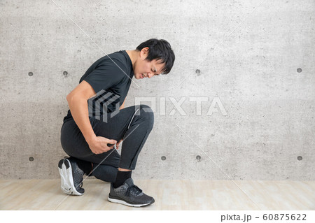 運動中に太ももを抑える男性（ハムストリングス・太股・筋肉痛） 60875622