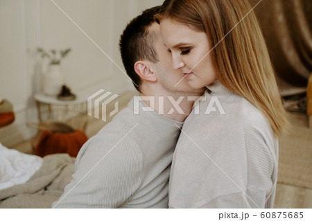 Pretty loving couple in bed together. They are hugging and smiling Pretty loving couple in bed together. They are hugging and smiling 60875685