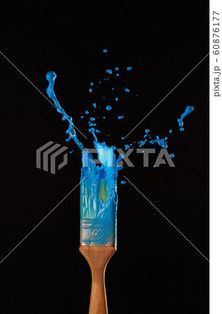 Brushes with spreading blue paint on blank black background 60876177