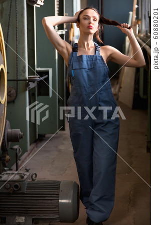 Attractive brunette girl dressed in overalls Attractive brunette girl dressed in overalls 60880201