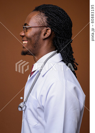 Young handsome African man doctor against brown background 60883195